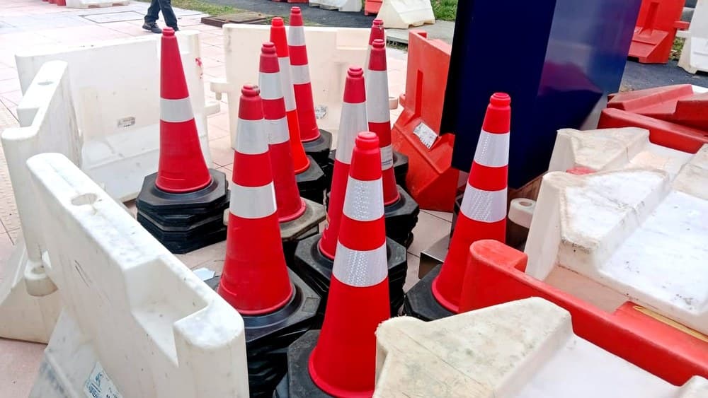 活动现场道路封闭前排列好的交通锥与红白塑料护栏。